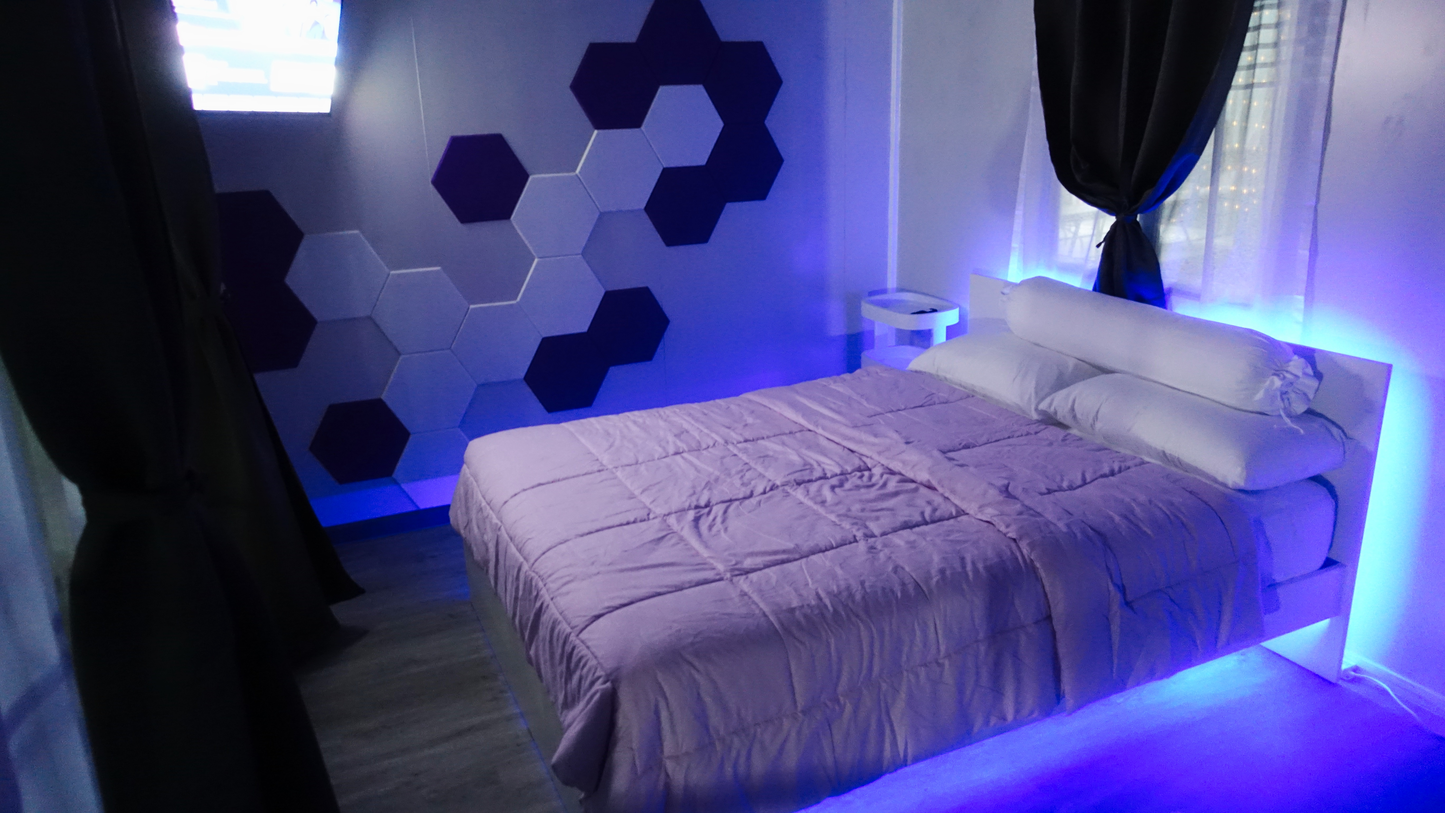 Modern room with blue LED lighting and hexagonal wall art