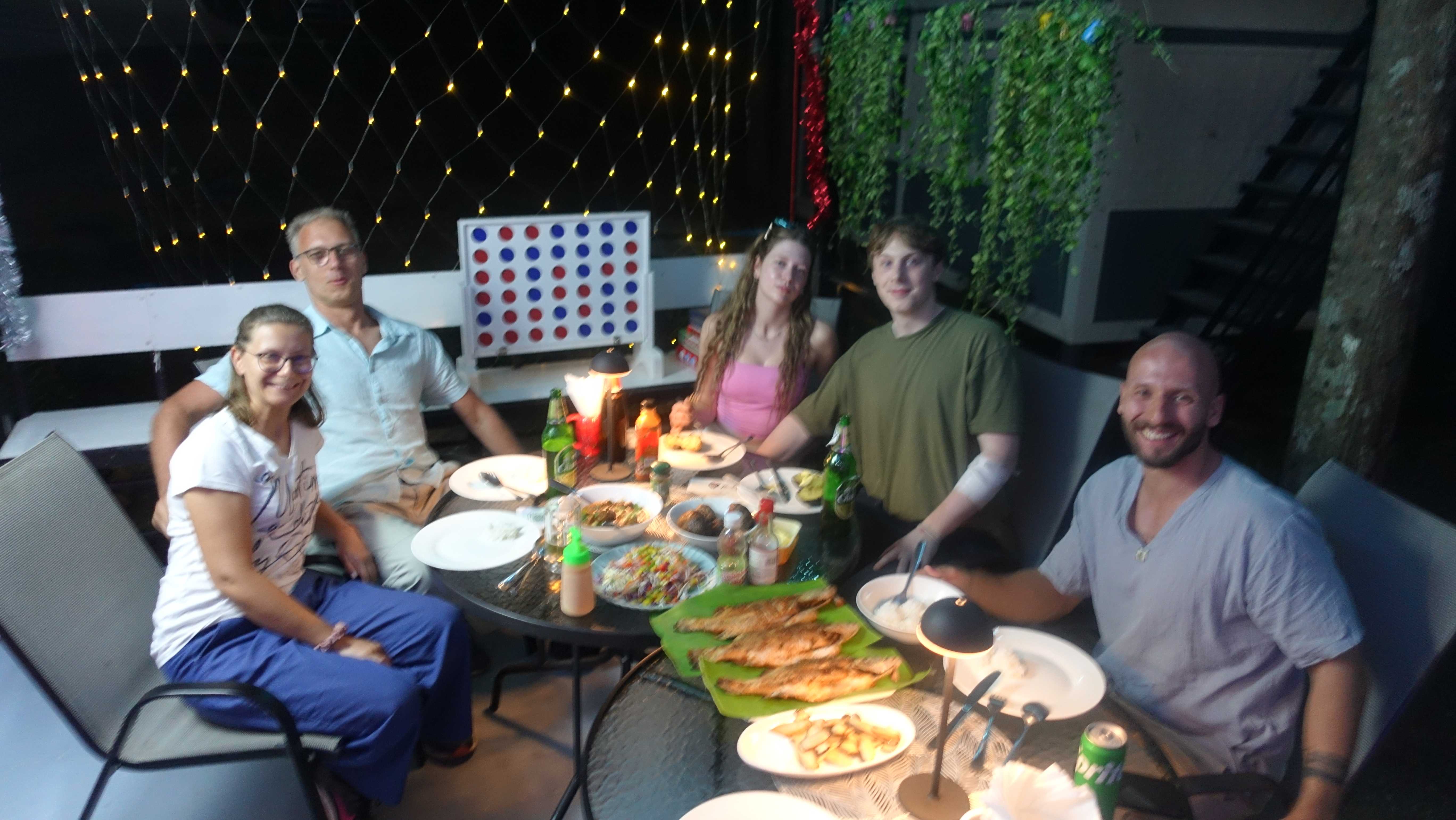 Guests enjoying dinner together on the terrace with string lights