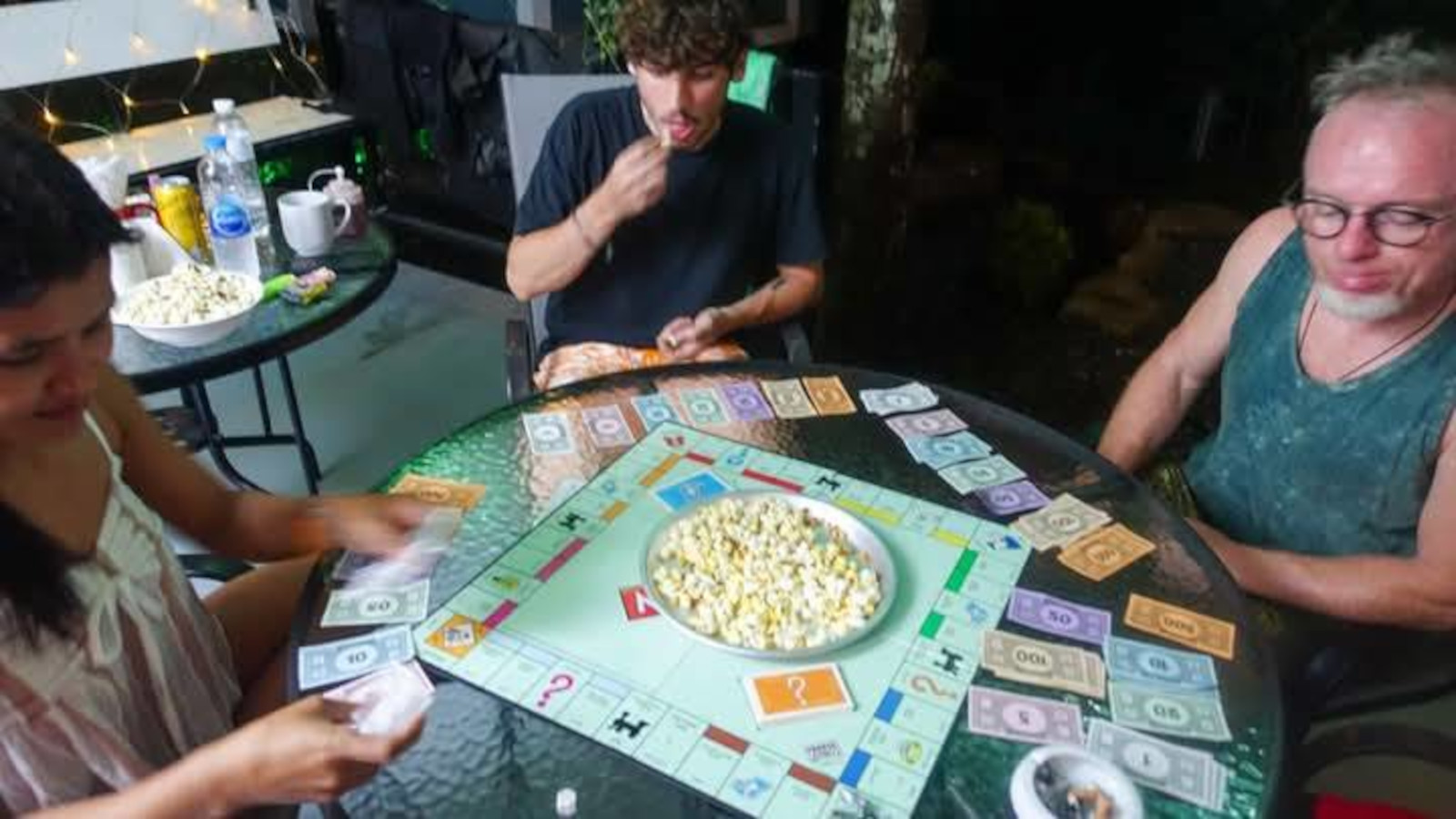 Guests playing Monopoly board game with popcorn on the terrace